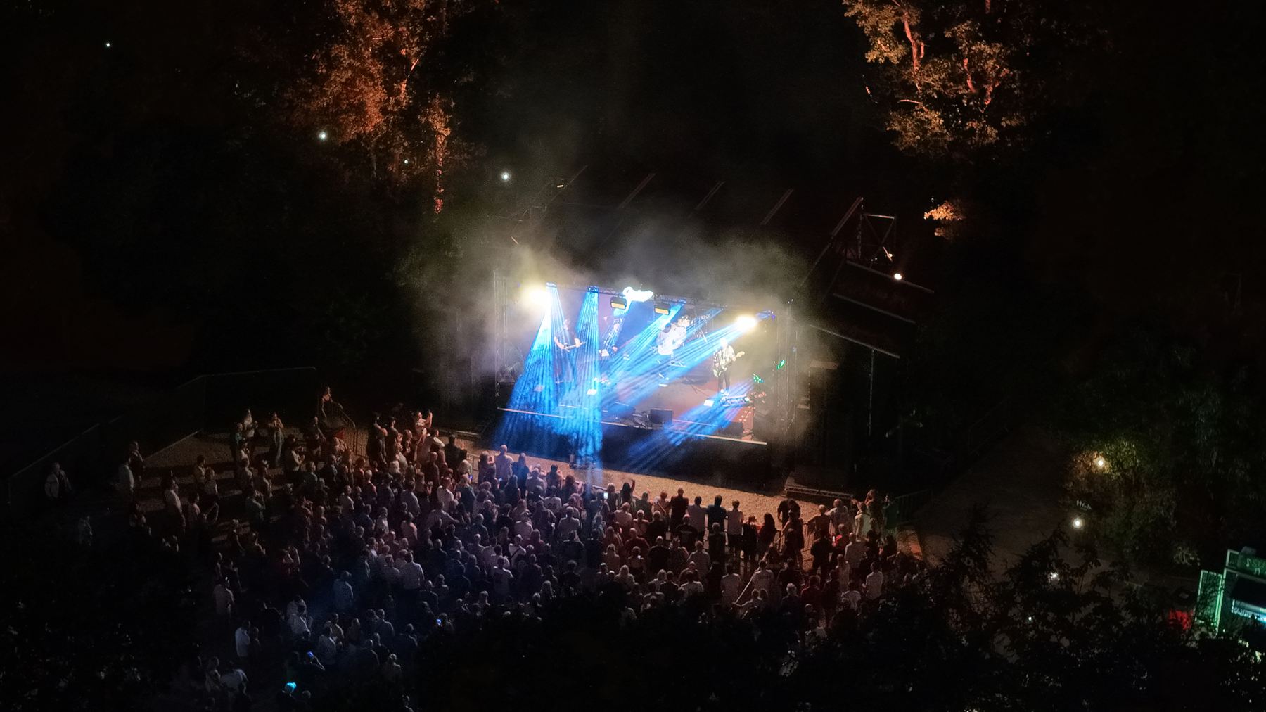 Aerial shot looking down on the Strings Festival stage at Robin Hill with blue beam lighting cutting through haze