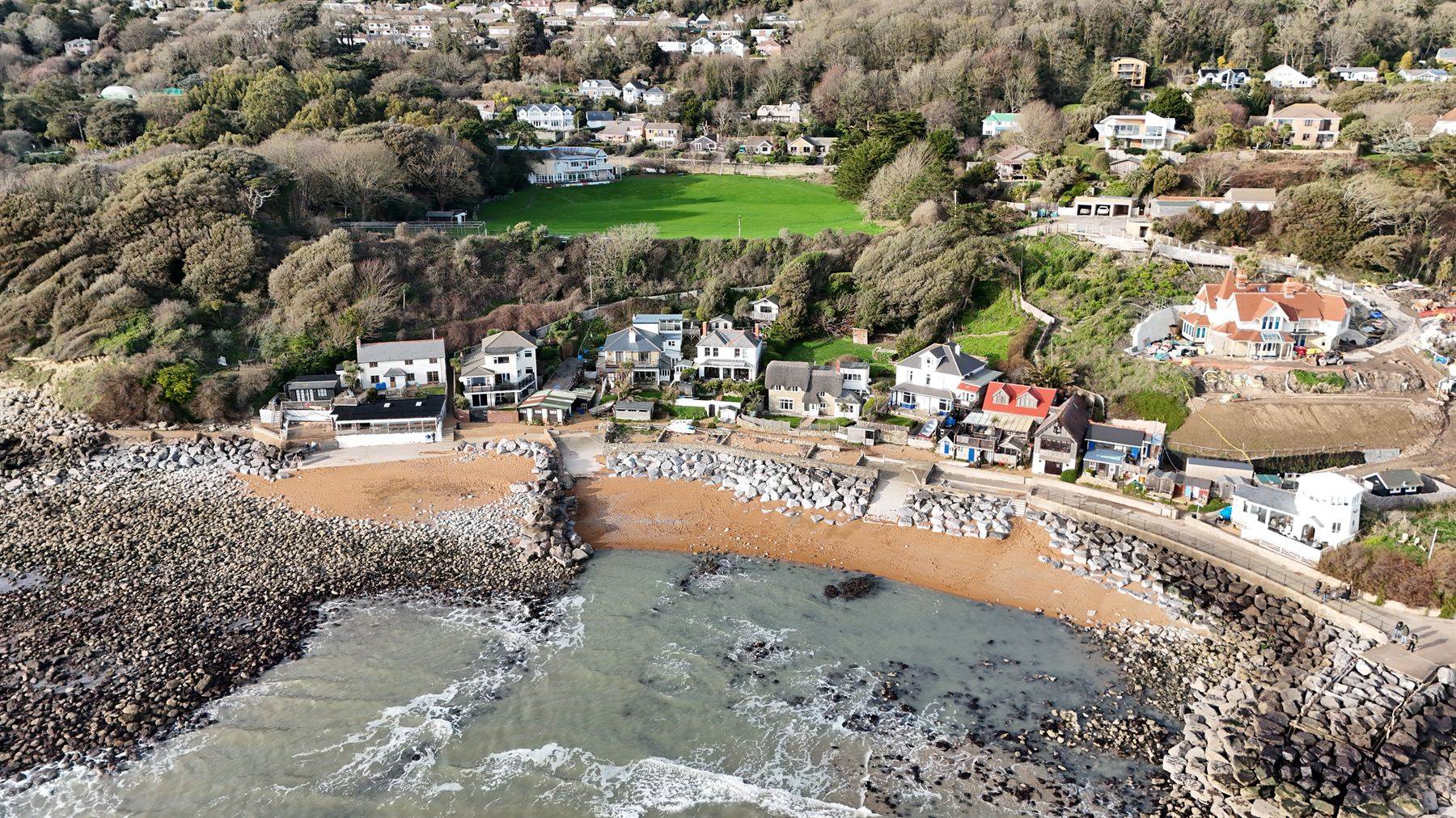 Aerial photograph over a coastal village, roof planes, chimneys and valleys visible from above